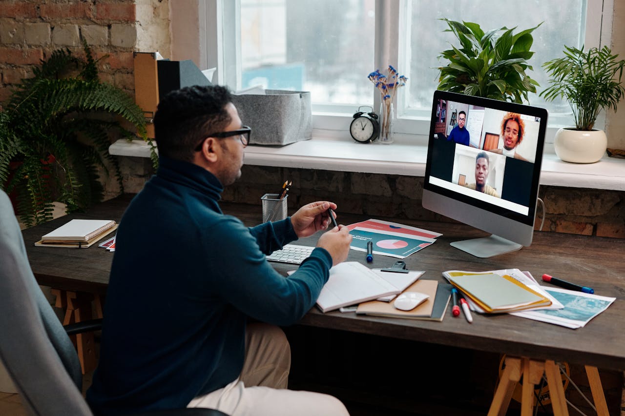 creative Man engaging in an online meeting from home office, showcasing remote work dynamics.